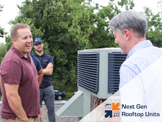 three people talking near a hvac system